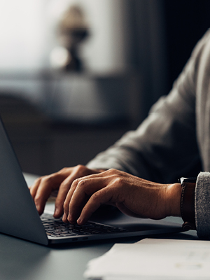 Hands typing on a laptop