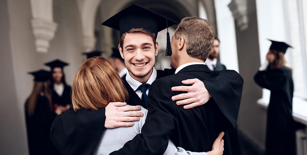 son hugging parents at graduation