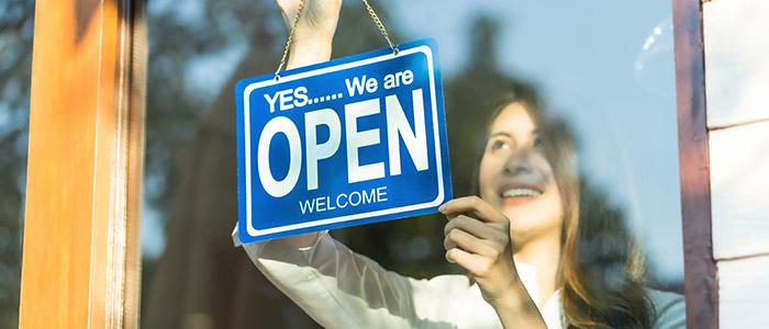 woman changing her business open sign